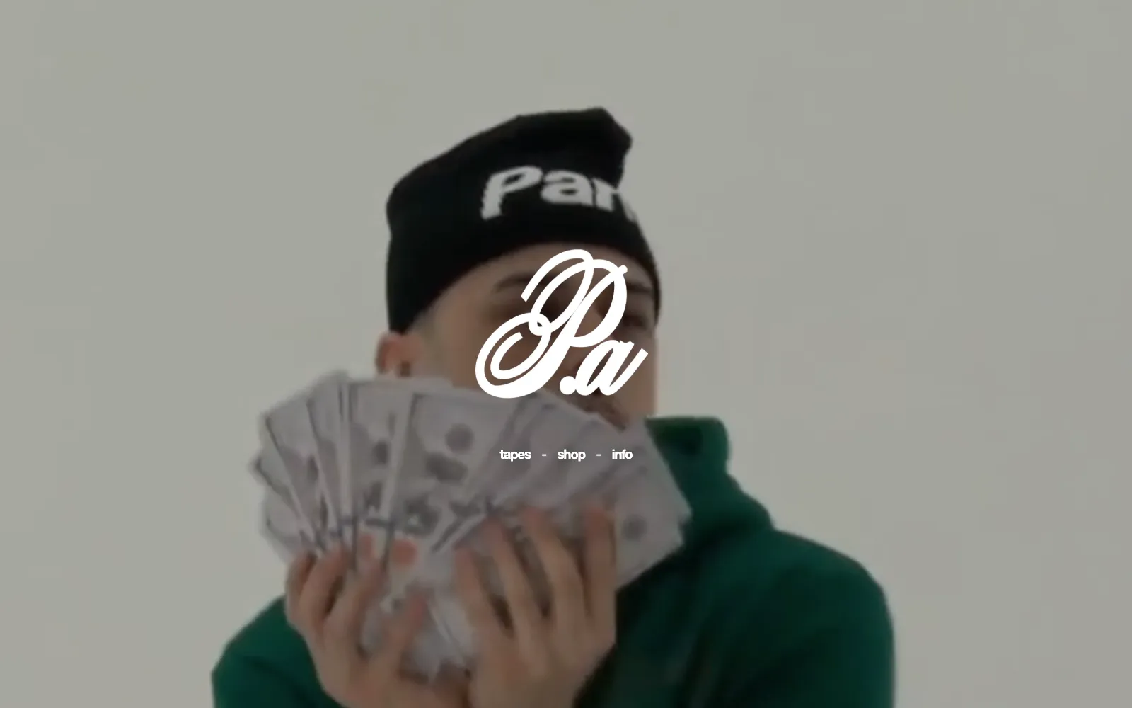 Parismo homepage: the brand's script logo in white over a full-screen brand film, with three links underneath reading tapes, shop and info